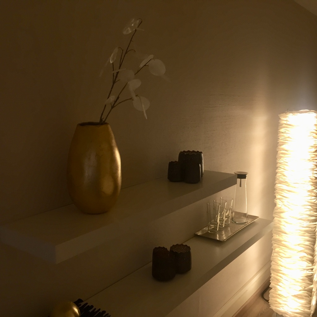 Salle d'attente. Lampe douce One by One de Belux. Une carafe, de l'eau et de la déco sur des planches à fixations invisibles, simple et linéaires.